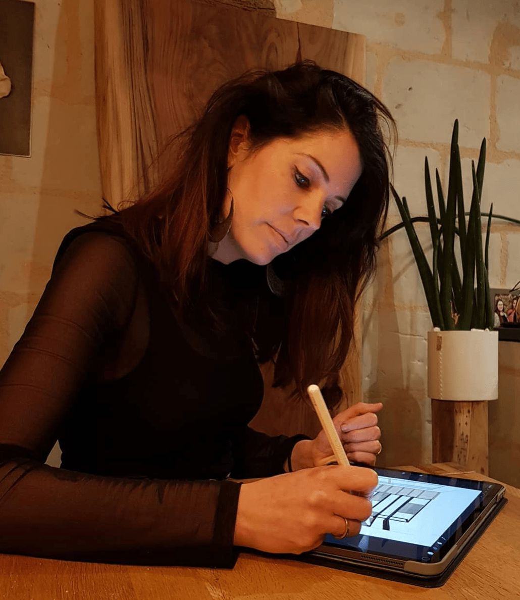 Cindy, créatrice de C Design Mobilier, dessine sur son iPad dans l'atelier